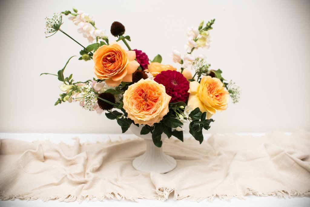 A vibrant selection of peachy garden roses and hot pink dahlias, contrasting with spires of blush snapdragon and echinacea seed heads for a textural element. Designed by Hart and Flowers based in Alexandra Hills on the Redlands Coast.