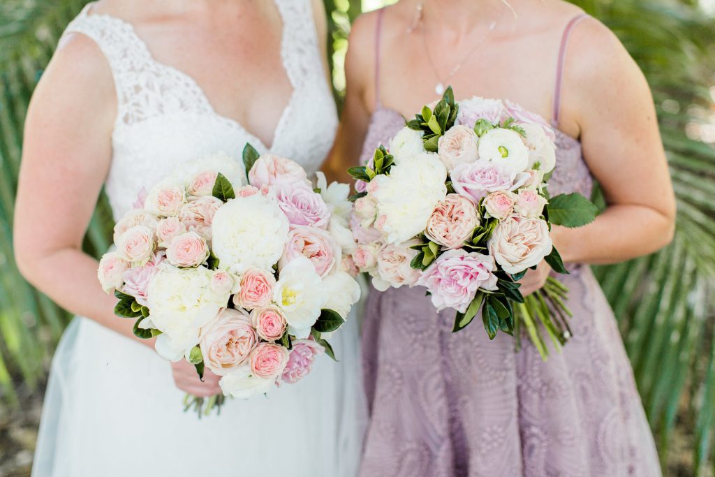 Romantic and elegant bridal and bridesmaid bouquets showcasing a soft color palette of pink and white. The bouquets feature a mix of lush peonies, delicate ranunculus, and romantic roses, creating a textural and captivating classic design.