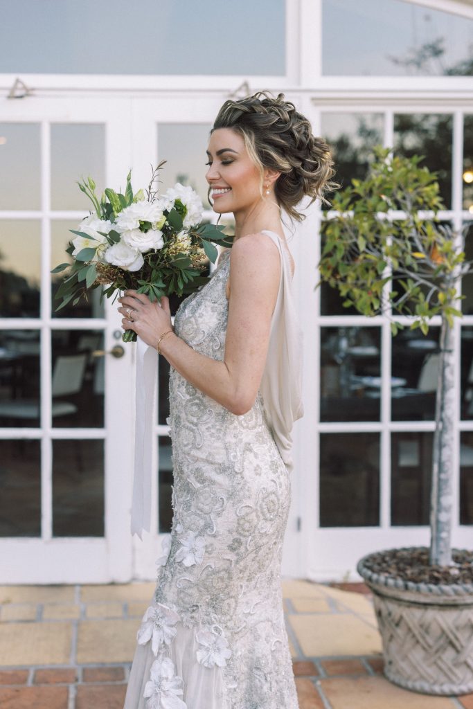 This exquisite bridal bouquet created by Hart and Flowers features locally sourced white dahlias, lush eucalyptus greenery, and delicate chincherinchee blooms, creating a timeless and elegant look for your wedding day.