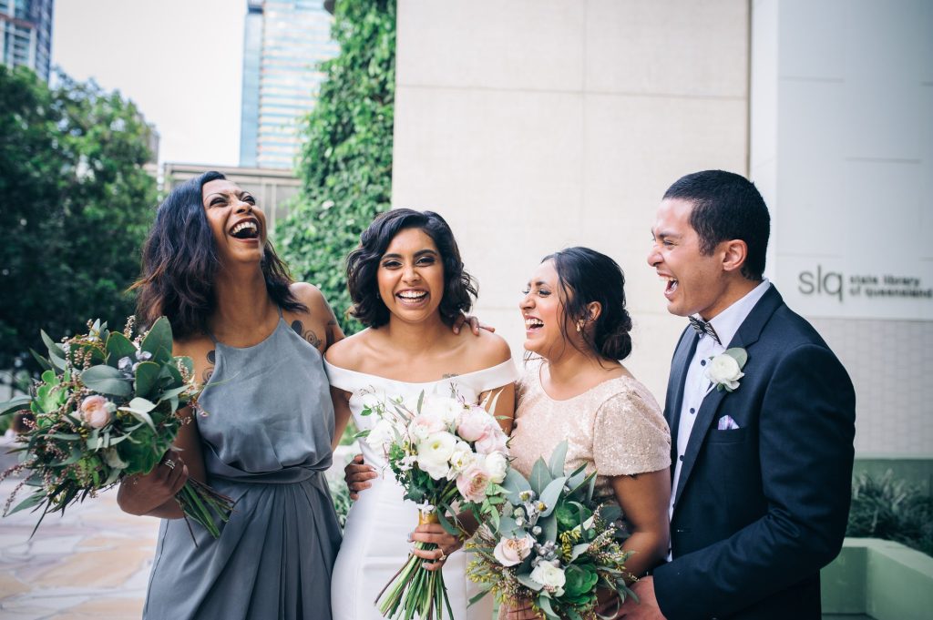 A romantic and elegant bridal bouquet showcasing a soft color palette of blush and white. The bouquet features a mix of lush tulips, delicate ranunculus, and romantic roses, creating a textural and captivating arrangement. The bridesmaids bouquets fe